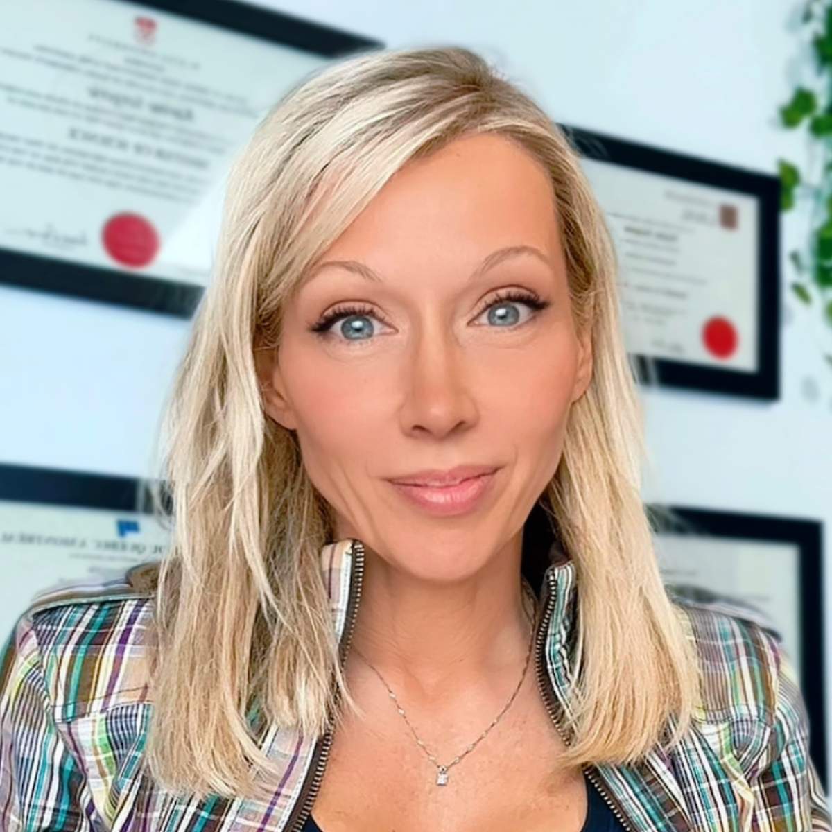 Portrait de Karine Sergerie, souriante, dans un environnement de bureau lumineux.